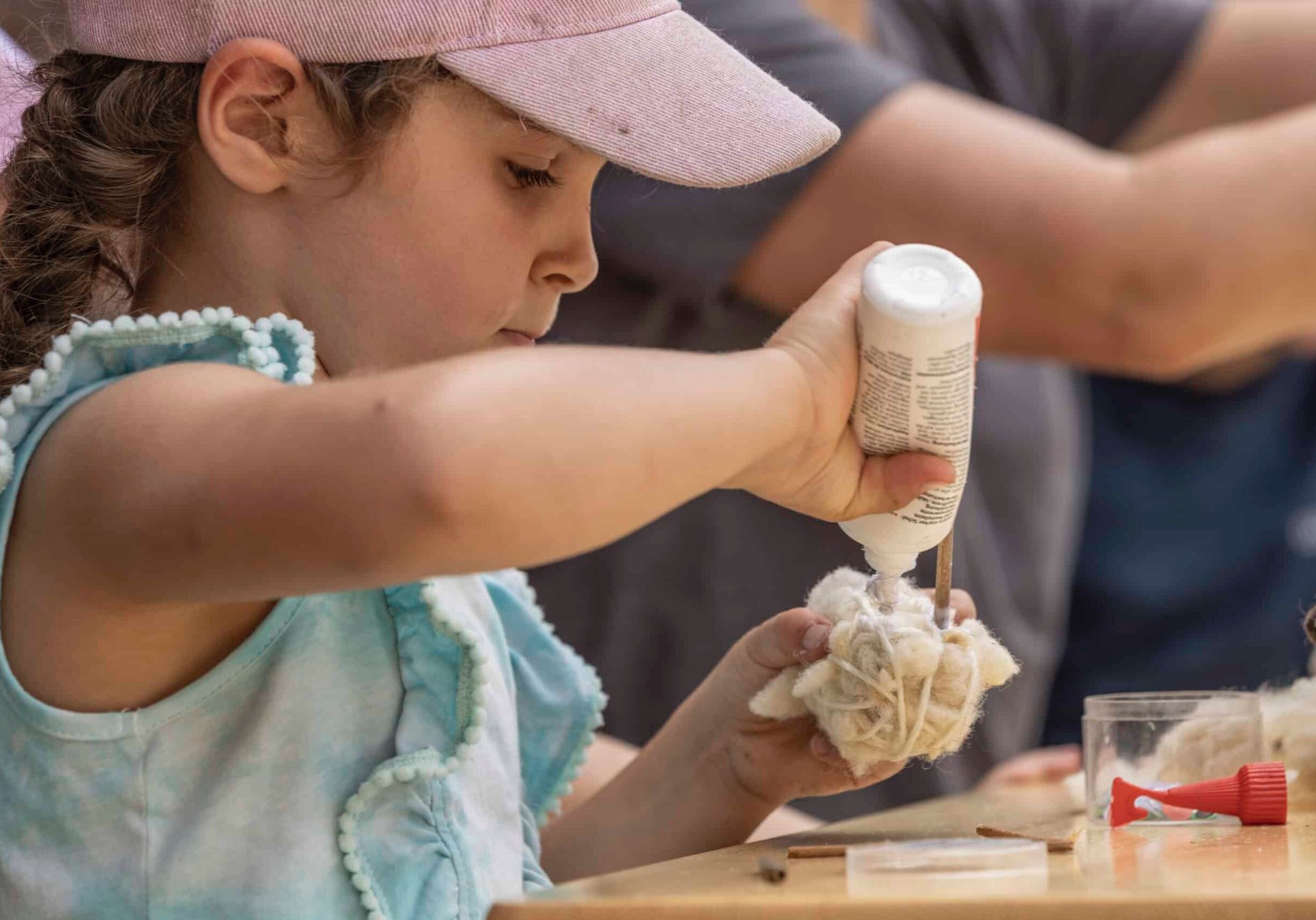 Kind beim Werken mit Wolle und Naturmaterialien