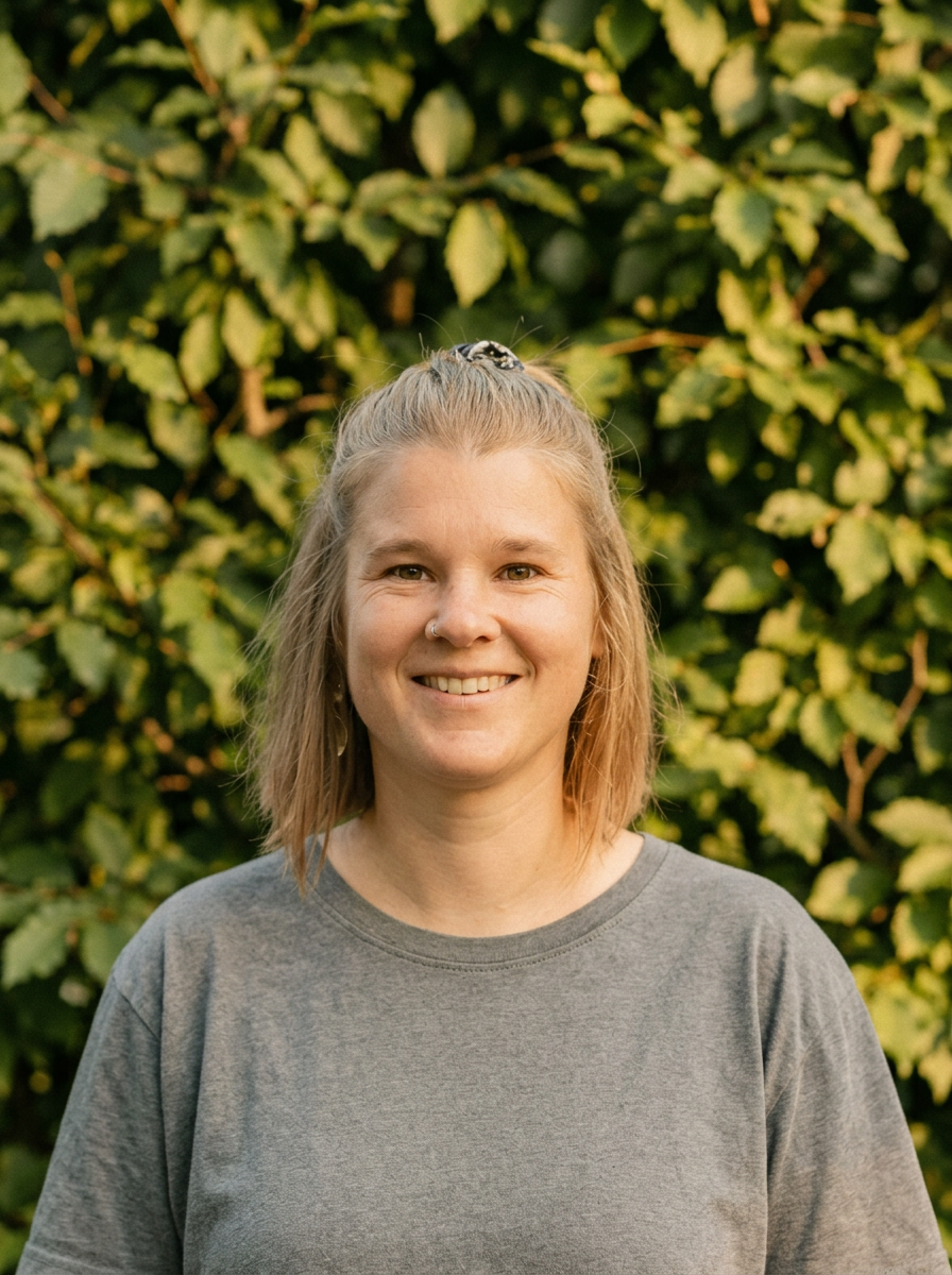 Portrait von Christine Huber vor grüner Hecke