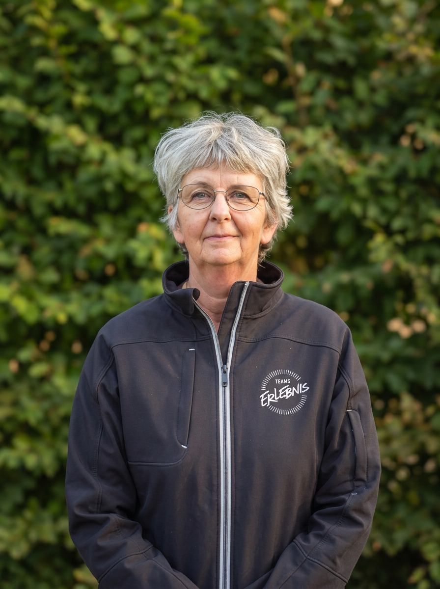 Portrait von Petra Messmer vor grüner Hecke